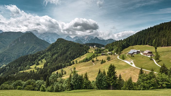 Scenic view of Slovenia's Logar Valley with mountains and green meadows
